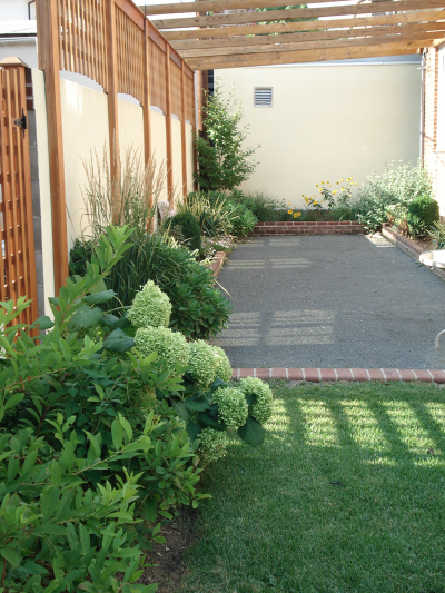 Custom Bocce court with wood pergola, brick raised beds and flowering shrub & perennial border Custom Bocce court with wood pergola, brick raised beds and flowering shrub & perennial border