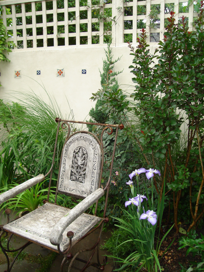 Stucco & wood trellis walls with inset decorative tile and shrub & perennial garden Stucco & wood trellis walls with inset decorative tile and shrub & perennial garden